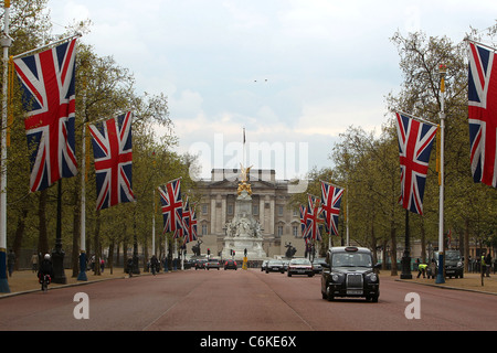 I preparativi per il royal wedding "Union Jack' linea di bandiere le strade si avvicina a Buckingham Palace. Il memoriale della Victoria visto Foto Stock