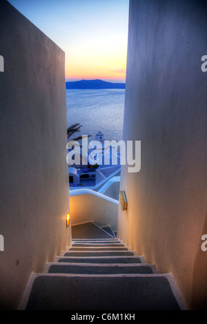 Guardando verso il basso i leggendari passi di Santorini, isola greca, grecia, tipico tramonto contro le pareti dipinte di bianco di edifici Foto Stock