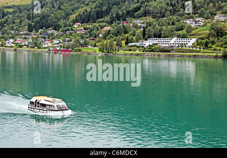 Una gara è il trasporto di passeggeri di una nave da crociera al molo anticato sul Innvikfjorden in Norvegia con Olden Fjordhotel destra Foto Stock