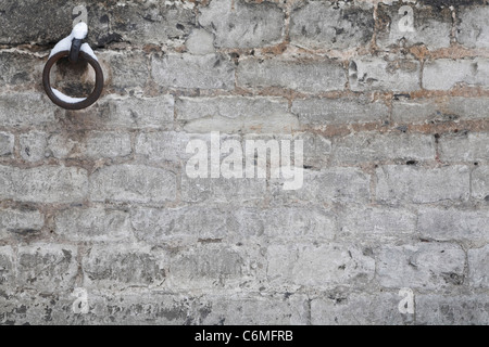 Dettaglio di un muro di pietra con ferro vecchio arrugginito anello, ideale per uno sfondo o un modello Foto Stock