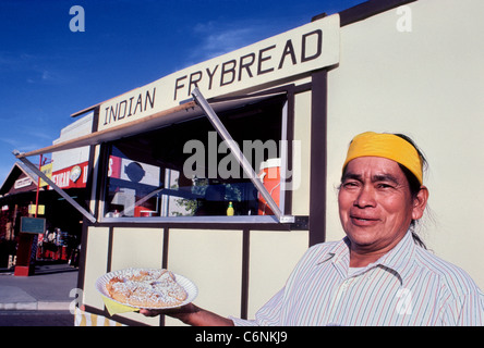 Un nativo americano l uomo sta al di fuori del suo cibo del fornitore di rimorchio per offrire un campione di Indiano Navajo frybread egli produce e vende in Arizona, Stati Uniti. Foto Stock