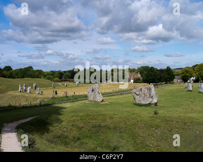 dh Avebury Stone Circle AVEBURY WILTSHIRE turisti intorno alla posizione megalitica cerchio di pietre e case di villaggio età neolitica henge Foto Stock