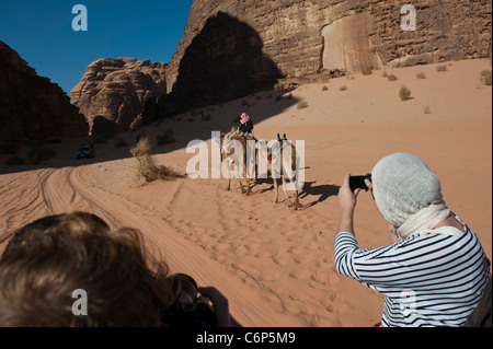 4x4 jeep safari passando un beduino camel rider wadi rum Giordania Foto Stock