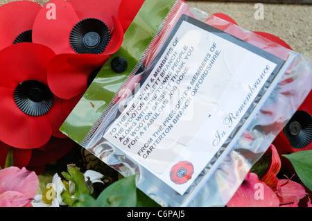 Le corone ed altri oggetti lasciati sul terreno intorno al Royal Wootton Bassett Memoriale di guerra. Foto Stock