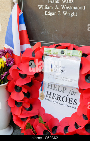 Le corone ed altri oggetti lasciati sul terreno intorno al Royal Wootton Bassett Memoriale di guerra. Foto Stock