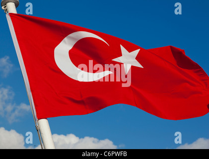 Bandiera turca sventolare nel vento contro un cielo blu con la nuvola bianca Foto Stock