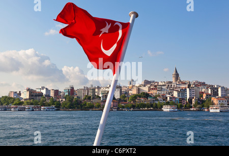 Torre di Galata, con un primo piano bandiera turca di un sistema di cottura a vapore, Beyoglu, Istanbul, Turchia Foto Stock