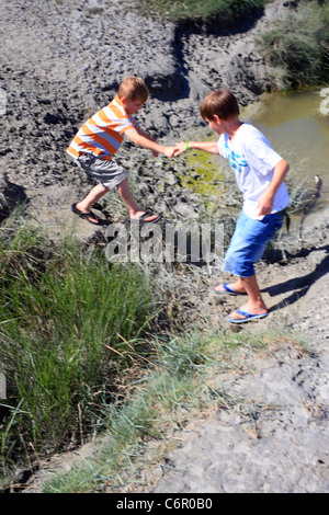 I ragazzi sul Salt Marsh nella baia di Le Mont Saint Michel a Le Gue de l'Epine, Avranches, Manche, Normandia, Francia Foto Stock