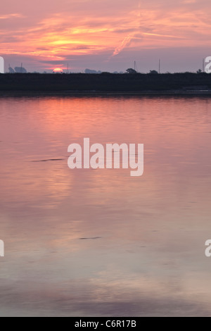 Sun appare sull'orizzonte che si affaccia Blackwater Estuary Foto Stock