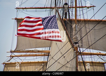 Una bandiera americana flutti del vento sulla vela windjammer nave Stella dell India al San Diego Maritime Museum. Foto Stock