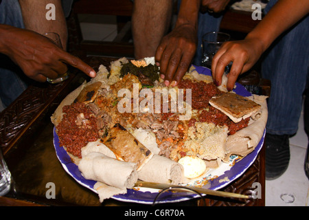 Etiope tradizionale pasto condiviso di injera (un grande pancake fatti da teff) e stufato. Foto Stock