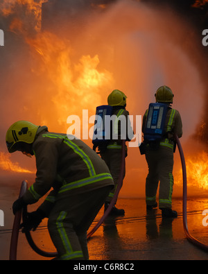 Vigili del fuoco antincendio che combattono il fuoco utilizzando tubi flessibili e apparecchi respiratori in Scozia, Regno Unito, Europa Foto Stock