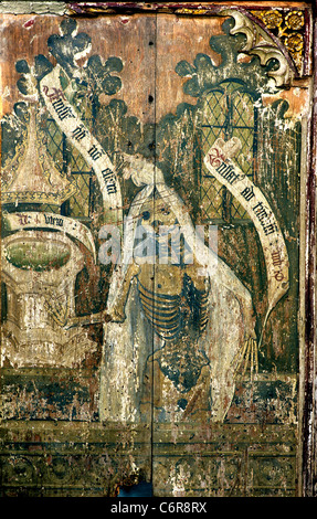 Sparham, Norfolk, Rood Screen, danza di morte, maschio scheletro vestito in un sudario punti alla chiesa font. Testo su pergamene Foto Stock