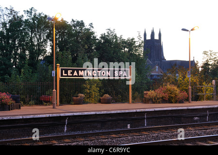 Leamington Spa stazione ferroviaria di segno e la parrocchia di Tutti i Santi la Chiesa all'alba, Warwickshire, Inghilterra, Regno Unito Foto Stock