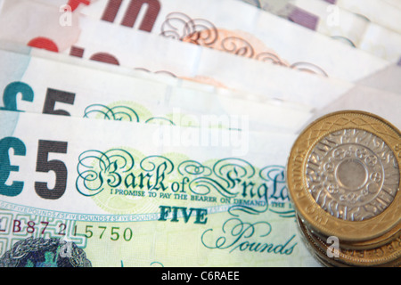 Sterling £2 monete sulla parte superiore della sterlina note Foto Stock
