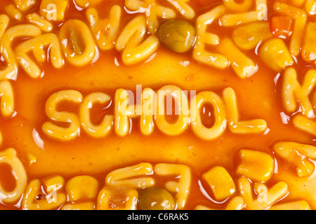 Alfabeto pasta sagomato formante la parola scuola in salsa di pomodoro Foto Stock