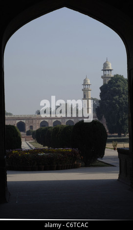 La vista attraverso uno degli archi del cancello di ingresso a due delle torri dell'Imperatore Jahangir la tomba di Lahore, Pakistan. Foto Stock