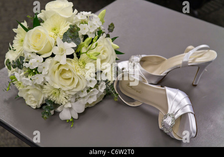 Le scarpe da sposa della sposa e un bellissimo bouquet di rose bianche sopra l'alto degli eventi scene di vita orizzontali negli Stati Uniti ad alta risoluzione Foto Stock