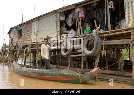 Uomo in una barca di shopping in un negozio su un affluente del lago Tonle Sap, a Kompong Klang villaggio nei pressi di Siem Reap, Cambogia Foto Stock