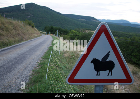 Attenzione, bassa battenti pecora! Questo ambiente rurale francese cartello stradale è stata modificata dal divertente aggiunta di ali per il simbolo di pecora. La Drôme, Francia. Foto Stock