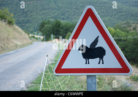 Attenzione, bassa battenti pecora! Questo ambiente rurale francese cartello stradale è stata modificata dal divertente aggiunta di ali per il simbolo di pecora. La Drôme, Francia. Foto Stock