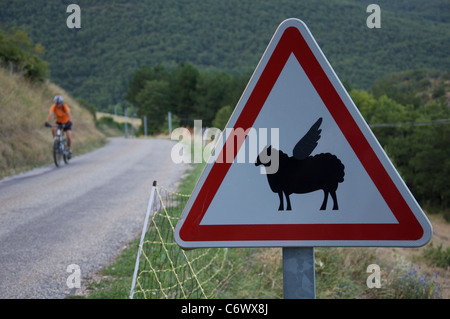 Attenzione, bassa battenti pecora! Questo ambiente rurale francese cartello stradale è stata modificata dal divertente aggiunta di ali per il simbolo di pecora. La Drôme, Francia. Foto Stock