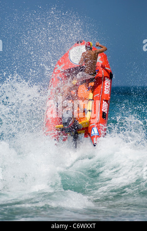 Un gonfiabile battello (IRB) salta attraverso il surf, quasi gettando il suo equipaggio. IRBs patrol più di Sydney spiagge. Foto Stock