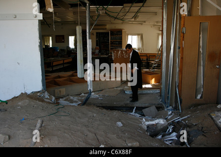 Un ragazzo ebreo è osservando la distruzione degli arredi del locale Sinagoga dopo un razzo grad attentato in Ashdod, Israele Foto Stock