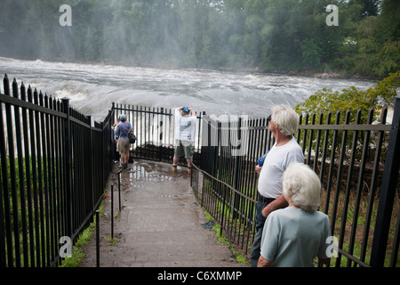 I visitatori su un look-out consente di riprodurre migliaia di galloni di acqua a cascata su grandi cascate del fiume Passaic in Paterson Foto Stock