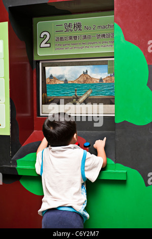 Bambino che gioca la guerra gioco arcade, 823 Battaglia di artiglieria museo della guerra, 23 agosto battaglia Storia Hall, Kinmen National Park, Taiwan Foto Stock