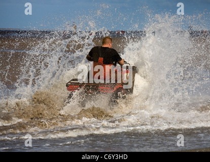 La mietitura Cocklers utilizzando ATV (ATV) "quad bikes" all'inizio dell'arricciatura stagione della raccolta, Southport, Merseyside, Regno Unito Foto Stock