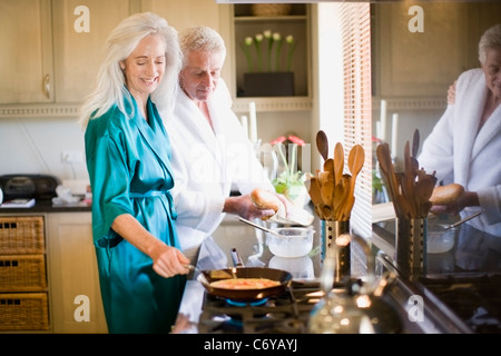 Coppia di anziani in accappatoi per la cottura Foto Stock
