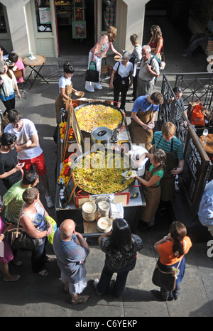 Enormi padelle di paella spagnola essendo preparato e cotto a vendere in Covent Garden London REGNO UNITO Foto Stock