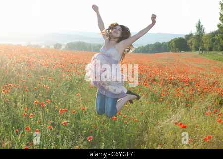 Donna incinta nel campo dei fiori Foto Stock