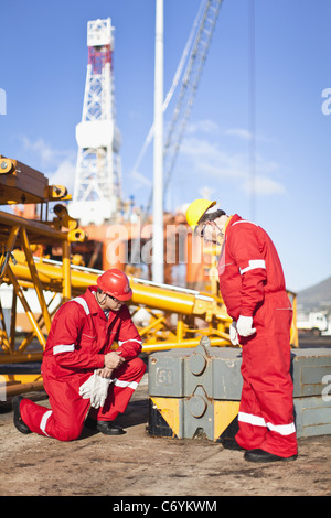 Lavoratori su piattaforma petrolifera esaminare le attrezzature Foto Stock