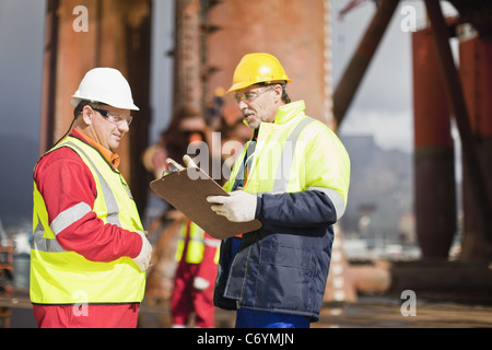 I lavoratori parlano su piattaforma petrolifera Foto Stock