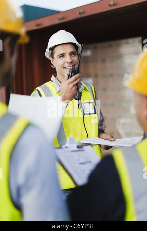 I lavoratori parlano in cantiere di spedizione Foto Stock