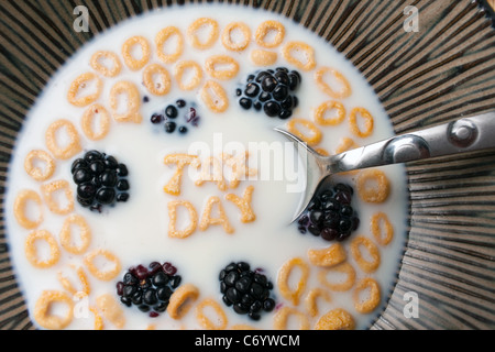 Le parole imposta giorno enunciato alla lettera a forma di pezzi di cereali galleggianti in un latte riempito ciotola di cereale. Foto Stock