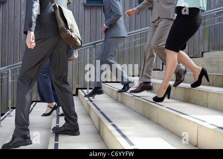 La gente di affari a piedi passi verso il basso Foto Stock