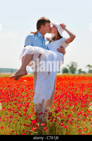 Giovane baciare in campo di papaveri Foto Stock