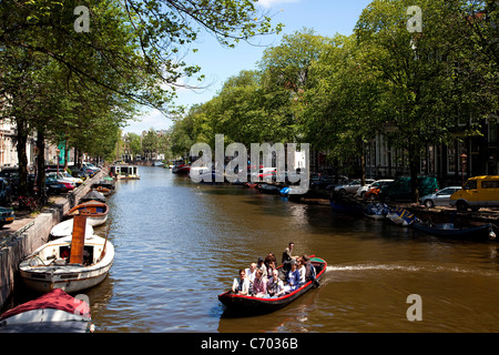 La barca turistica e canali di acqua in Amsterdam, Paesi Bassi Foto Stock