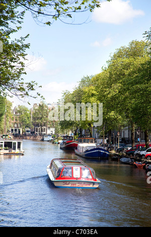 La barca turistica e canali di acqua in Amsterdam, Paesi Bassi Foto Stock