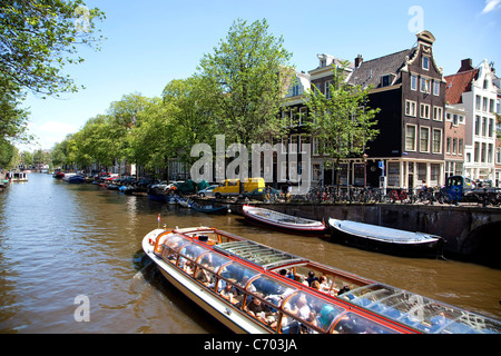 La barca turistica e canali di acqua in Amsterdam, Paesi Bassi Foto Stock