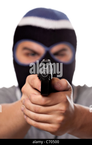 Un arrabbiato cerca uomo che indossa una maschera da sci puntando una pistola nera al visualizzatore. Profondità di campo. Foto Stock