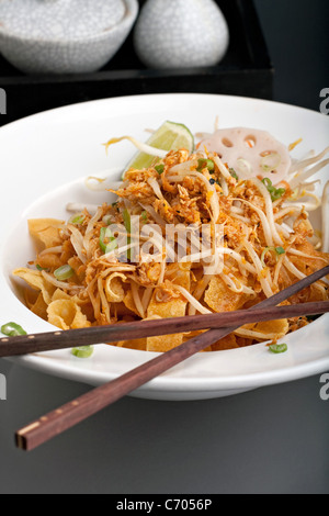 Un piatto tailandese di crisy tagliatelle e i germogli di soia in una grande ciotola bianca con i bastoncini. Foto Stock