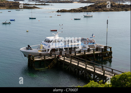 Imbarcazione turistica Jolie Francia II ormeggiata lungo Jetty ad alta marea sulla Grande Ile nell'Iles Chausey. Foto Stock