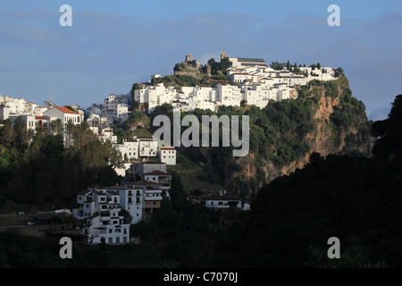 Nel tardo pomeriggio la luce del sole splende sulle bianche case dipinte e castello moresco di Casares, [pueblo blanco] in Andalusia, Spagna Foto Stock