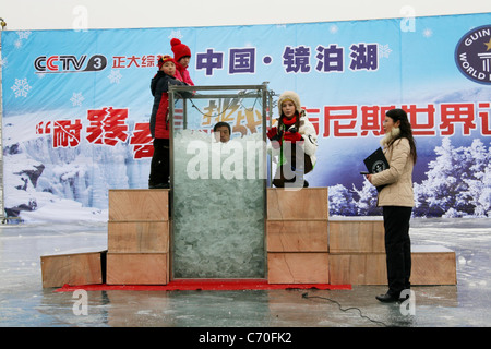 Uomo di Ghiaccio stabilisce un nuovo record del mondo un uomo in Cina ha stabilito un nuovo record mondiale per il tempo più lungo trascorso in piedi in ghiaccio. Il bizzarro Foto Stock