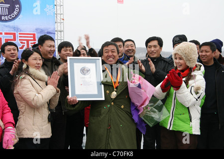 Uomo di Ghiaccio stabilisce un nuovo record del mondo un uomo in Cina ha stabilito un nuovo record mondiale per il tempo più lungo trascorso in piedi in ghiaccio. Il bizzarro Foto Stock