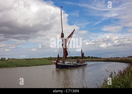 Tradizionale con fondo piatto Thames barge navigando sul fiume Alde, Snape, Suffolk, Regno Unito. Foto Stock